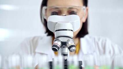 Woman scientist using microscope in laboratory. Microbiology science concept