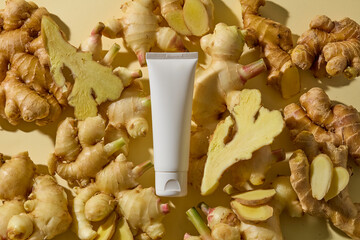 A product tube surrounded by an abundant spread of fresh ginger roots, creating a rich natural...