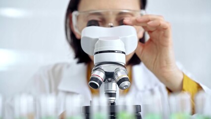 Woman scientist using microscope in laboratory. Microbiology science concept
