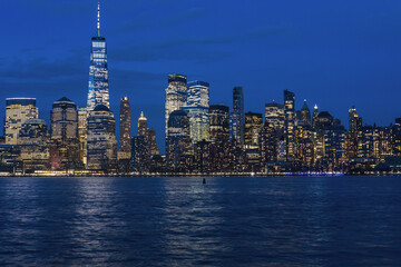 Obraz premium City skyline illuminated at night, with sparkling lights and towering buildings