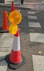 Cono de construcci&oacute;n naranja con una l&aacute;mpara en las obras de mantenimiento de una calle 