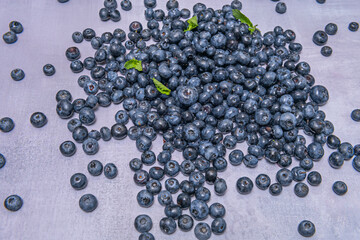 Wild blueberries in detail, showing their round shape and smooth skin, on a rustic, weathered wooden surface