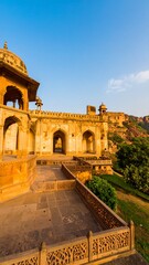 Fototapeta premium Sandstone structure, hilltop setting, arched entryways, intricate carvings, sunny day