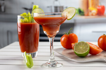 Glasses of bloody cocktails with lime and tomatoes