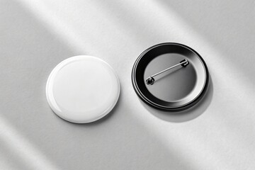 Two blank round badges one open showing pin mechanism
