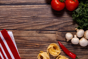 A collection of fresh ingredients arranged on a rustic wooden surface, suggesting preparation for cooking.