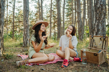 Two female friends or sisters setting up tent for the night in the forest