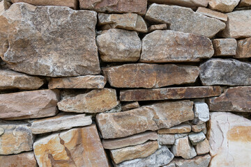 The wall is constructed from various sizes and shapes of natural stones.