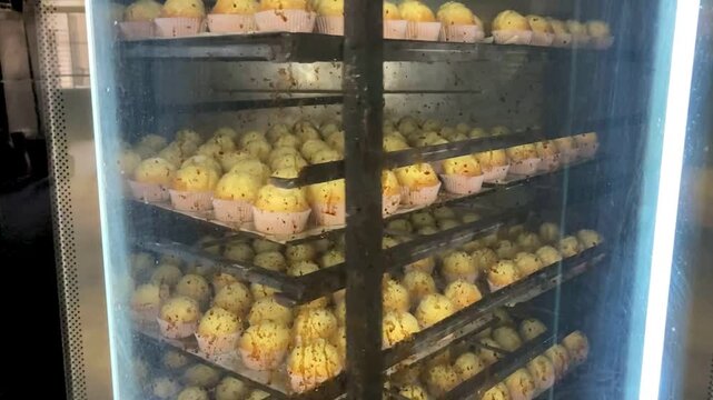 Madalenas haci&eacute;ndose en el horno de un obrador, en la trastienda de una panader&iacute;a
