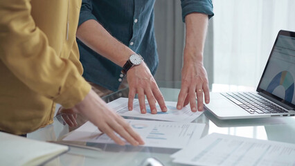 Business people, professionals analyzing financial charts and data on a desk while standing and...