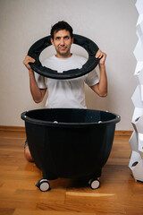 Experienced gardener assembling components of hydroponic system, holding circular part over black...