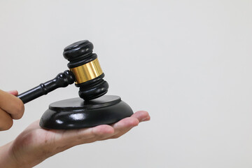 Judge gavel and block on hand is used for lawyer, law, justice, auction business. Side view