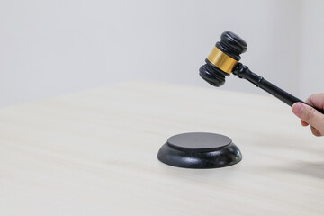 Holding a gavel the judge makes a gesture of knocking down a block is often associated with...