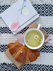 Cup of tea, croissant, and open notebook. Peaceful moment of journaling and presence.