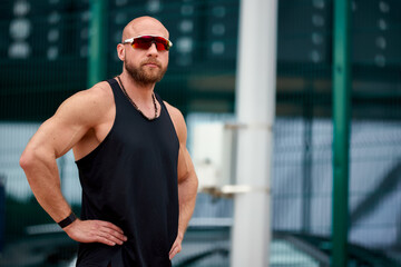Athletic man in sportswear outdoors in a casual sporty pose