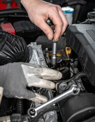 Mechanic hands working on a car engine. Professional garage lighting illuminates the details of an automotive workshop, symbolizing skilled repair and expert vehicle service