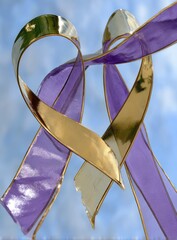 Heart-shaped ribbons, gold and purple, against a sky