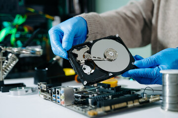 Technician repairing inside of hard disk drive by screwdriver. the concept of data, hardware,...