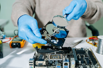 Technician repairing inside of hard disk drive by screwdriver. the concept of data, hardware,...