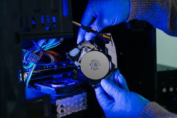 Hard disk drive on the technician's desk and a computer motherboard as a component. the concept of...
