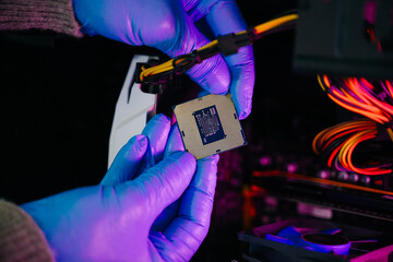 The technician is putting the CPU on the socket of the computer motherboard. electronic engineering...