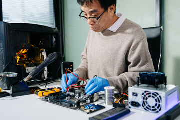 Skilled electronics technician repairing a computer motherboard with tools and precision in a...
