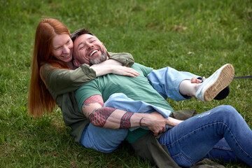 Happy couple sharing playful moment outdoors in green grass park