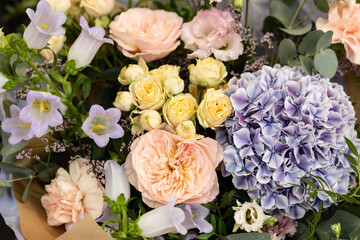 Beautiful bouquet of pastel colored flowers including hydrangeas, roses, and bellflowers, creating a romantic and elegant arrangement