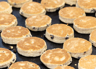 Freshly made welsh cakes cooking on a griddle, a traditional treat in Cardiff