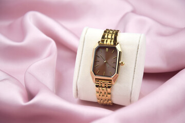 Closeup minimal fashion wristwatch for women on pink background.