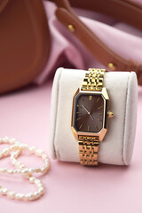 Closeup minimal fashion wristwatch for women on pink background.