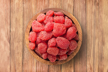 candied fruit, dried strawberry with sugar in bowl on wooden table background, top view. organic...