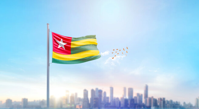 Togo national flag waving with skyline and buildings. Togo national flag for independence day.