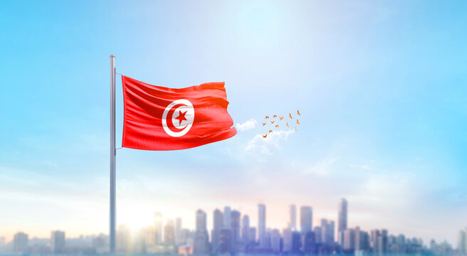 Tunisia national flag waving with skyline and buildings. Tunisia national flag for independence day.