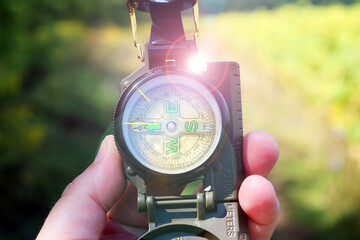 Classic navigation compass in your hand on natural background