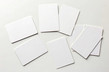 Blank white cards scattered on a clean white surface offering room for text