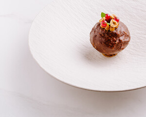 Chocolate dessert with nuts and berries displayed on a white plate