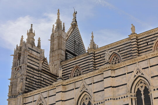 View from Piazza Jacopo della Quercia to the Duomo or Cathedral SE side and rear of the facade upper part by Camaino di Crescentino. Siena-Tuscany-194