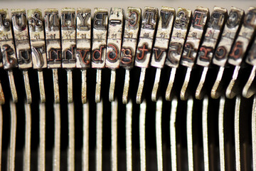 Vintage Typewriter Keys in a Row. A close-up, horizontal view of the metal type bars and hammers of...