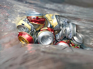 Shredded aluminum cans in a plastic bag, ready for recycling. Symbol of environmental care, waste...