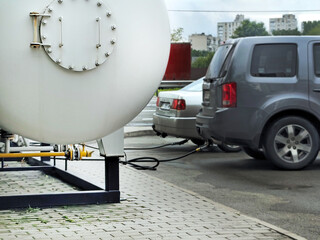 Cars refueling with LPG at a gas station. Focus on the process of alternative fuel usage and...