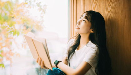 窓際で読書をする女性