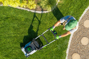 Lawn Care Professional Mowing Grass in a Well-Maintained Garden