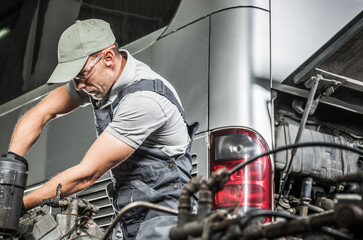 Mechanic Repairs Engine in Workshop During Daytime Hours