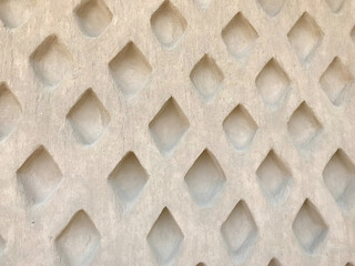 Close-up of a marble-textured wall featuring a diamond-shaped recessed pattern, creating an elegant...