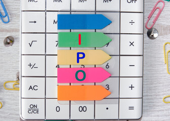 IPO text on colored stickers lying on the calculator. IPO is Initial Public Offering