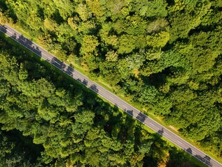 A country road winds through forests and meadows photographed with a drone
