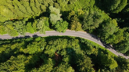 A country road winds through forests and meadows photographed with a drone