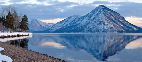 Calm winter lake reflecting snow-capped mountains