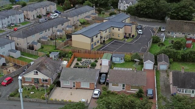 Aerial view over Welsh suburban neighbourhood community property rooftops and gardens